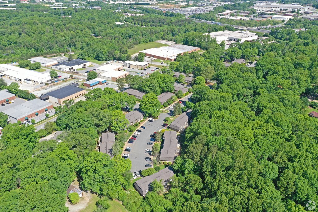 an aerial view of a city with cars parked in a parking lot