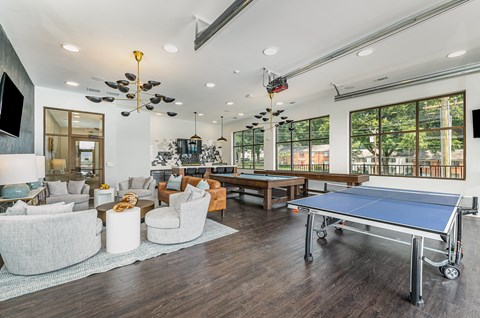 a game room with a ping pong table, a pool table, and table shuffleboard