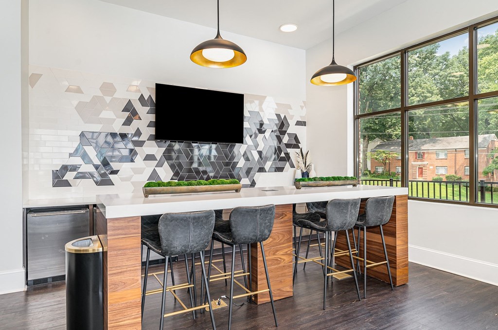 a kitchen with a long island with stools and a large window with a view of a