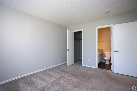 A room with a carpeted floor and a toilet in the open doorway.
