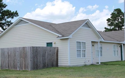 A house with a grey roof and a wooden fence.