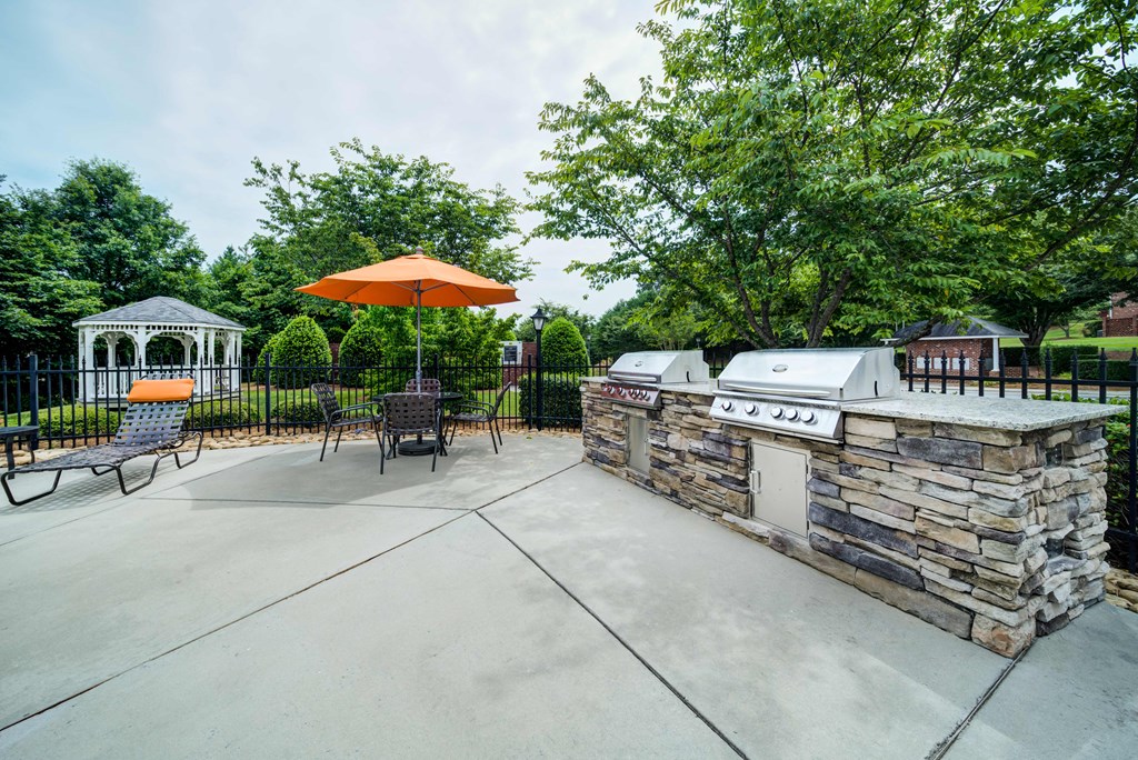 Umbrella Tables with Gas BBQ Grills adjacent to Pool Area and Gazebo