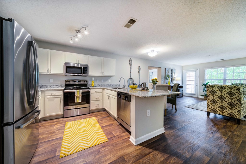 Open Floor Plan showing Kitchen with Bar, Dining Area, and Living Room