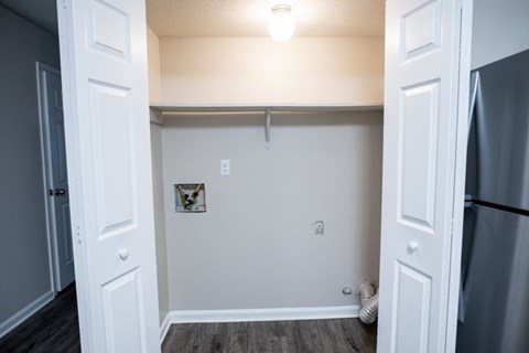 A small white kitchen with a refrigerator on the right.