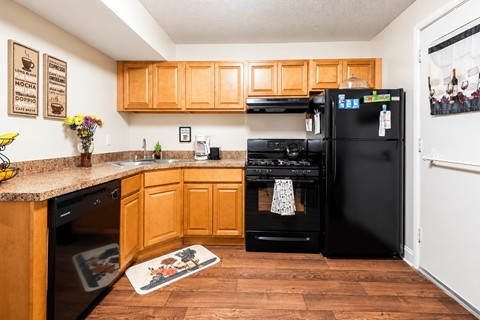 A kitchen with wooden cabinets and black appliances.
