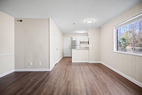 A kitchen area with wood flooring and white walls.