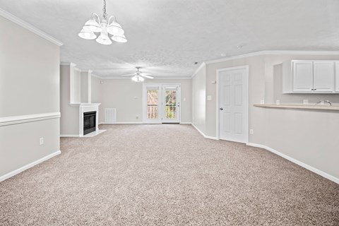 A spacious living room with a fireplace and a carpeted floor.