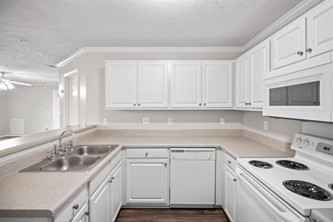 A kitchen with white cabinets and appliances.