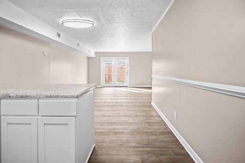 A kitchen with white cabinets and a marble countertop.