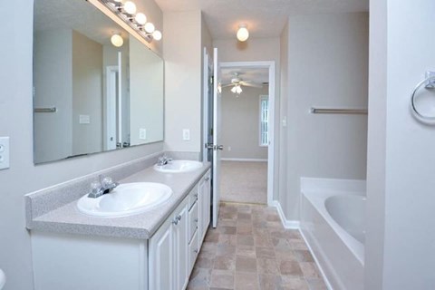 A bathroom with a white sink and a white tub.