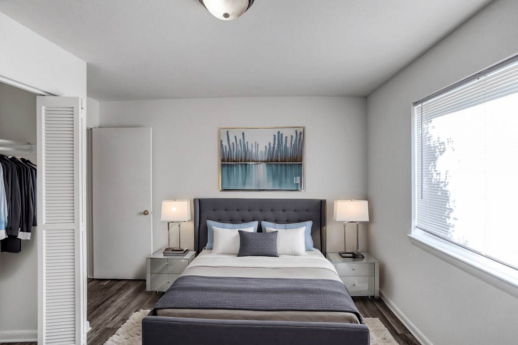 A bedroom with a large bed and a painting above it.