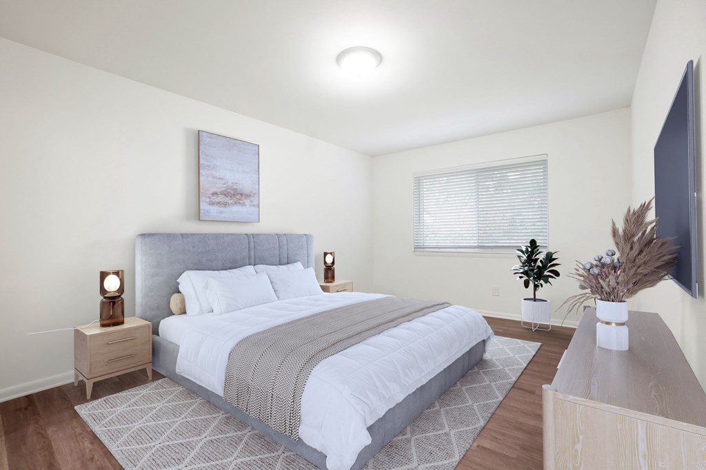 A bedroom with a large bed and a flat screen TV mounted on the wall.