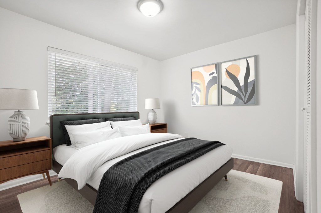 A bedroom with a large bed and two lamps.