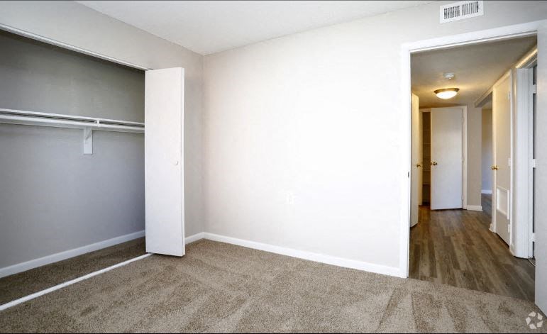 an empty room with a door to a closet