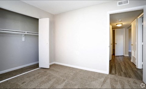an empty room with a door to a closet