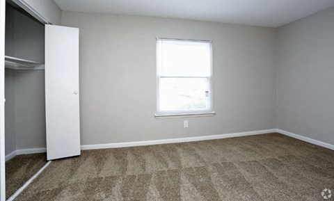 an empty room with a window and a door