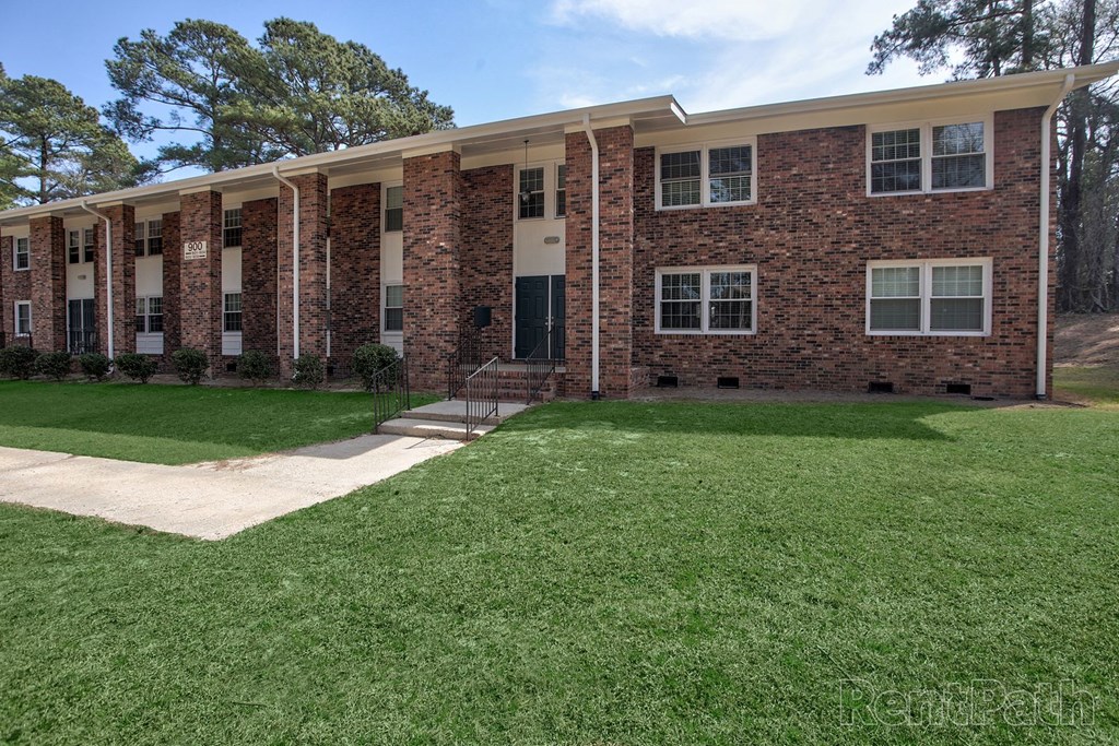 A brick building with a green lawn in front.