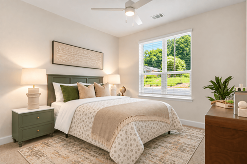 A bedroom with a bed, nightstand, and window.