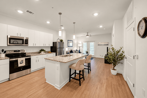 A kitchen with white cabinets and a granite countertop.