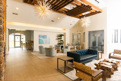 A living room with a blue couch and a wooden floor.