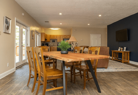 A dining room with a wooden table and chairs.