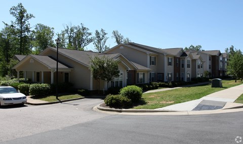 A white car is parked in front of a house.