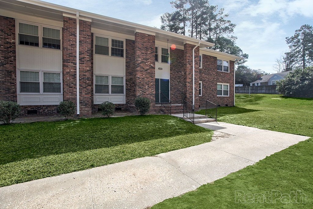 A brick building with a white door and windows.