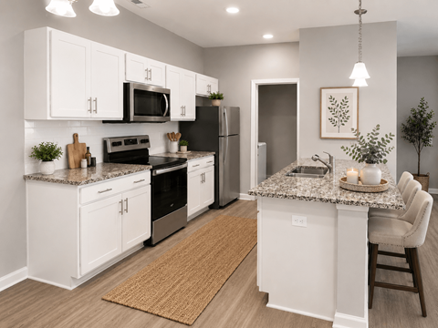 A kitchen with white cabinets and a granite countertop.