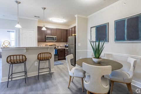 A kitchen with a table and chairs.