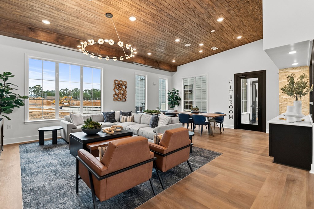 A modern living room with a wooden ceiling and a large window.