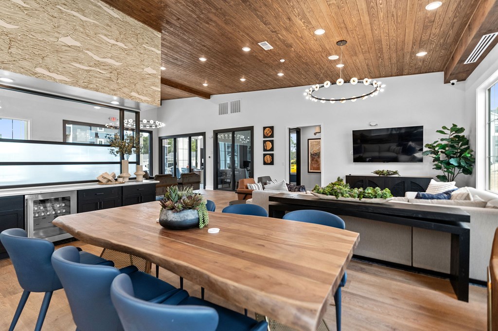 A modern dining room with a wooden table and blue chairs.