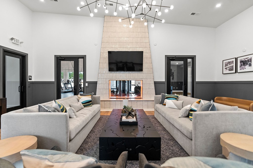 A living room with a grey couch and a black coffee table.
