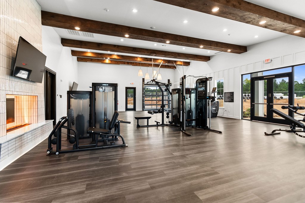 A gym with a variety of equipment including treadmills, weights, and exercise machines.