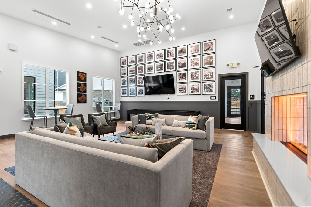 A modern living room with a grey sofa set and a chandelier.