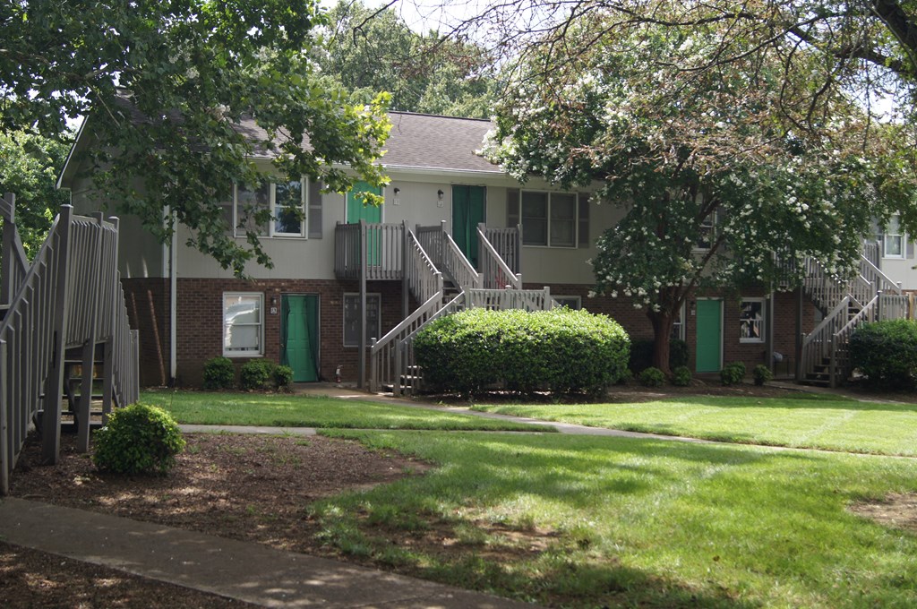 an apartment building with stairs and green doors