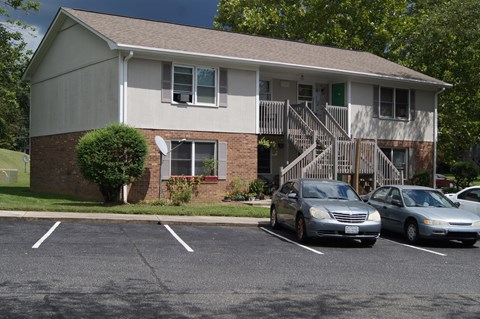 an apartment building with cars parked in a parking lot