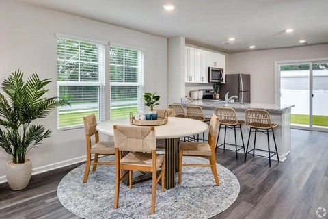 A dining room with a round table and chairs.