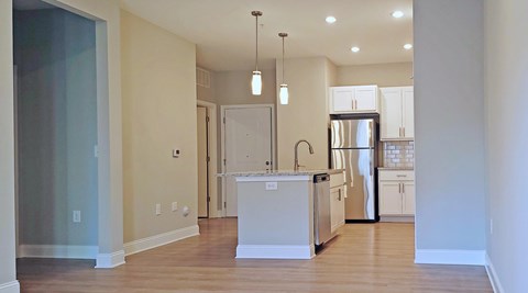 A kitchen with a white island and stainless steel appliances.