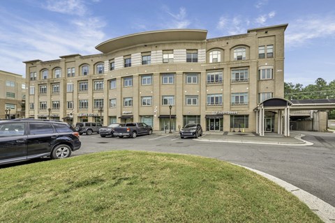 A large building with a curved top and cars parked in front.