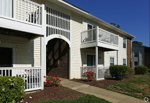 an apartment building with a balcony and a walkway