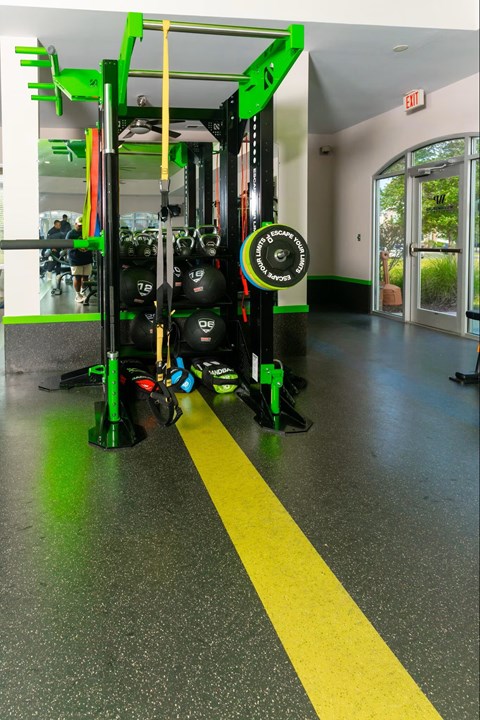 A gym with a green and black weight rack.