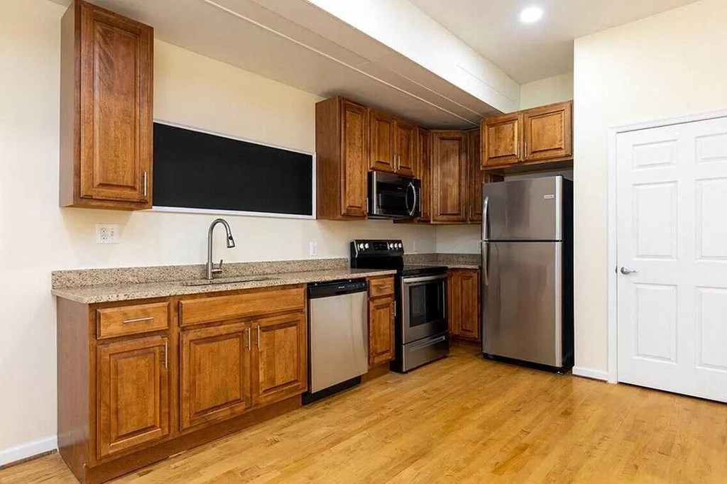 a kitchen with wooden cabinets and a stainless steel refrigerator