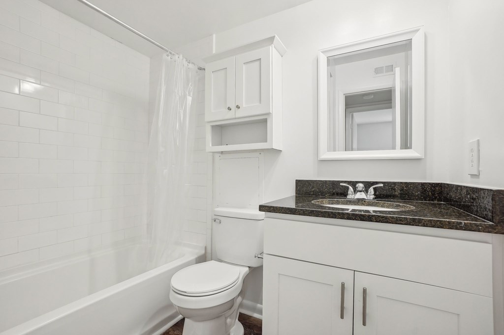 A white bathroom with a toilet, sink, and bathtub.