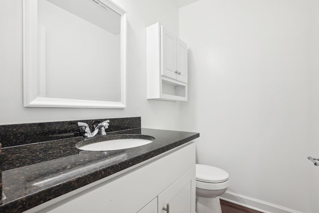 A bathroom with a sink, toilet and medicine cabinet.
