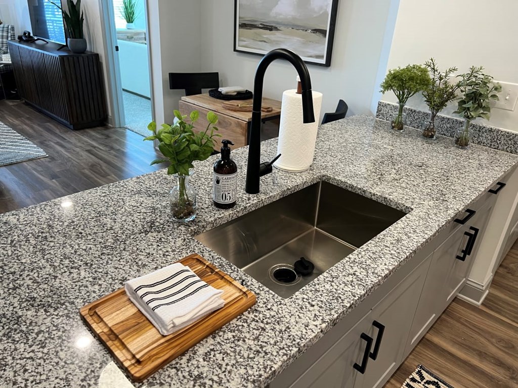 A kitchen with a granite countertop and a sink.