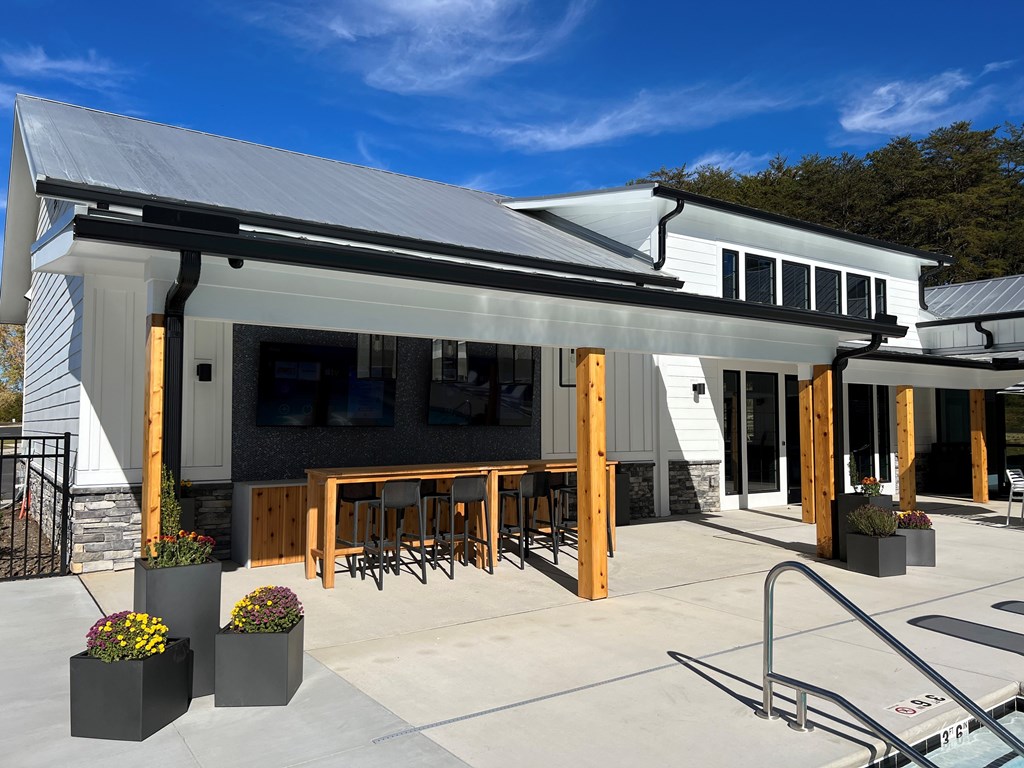 A modern building with a patio and outdoor furniture.