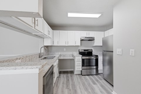 A modern kitchen with stainless steel appliances and white cabinets.