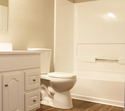 A white toilet sits next to a white sink in a bathroom.