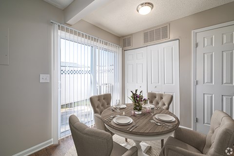 A dining room with a round table set for four.