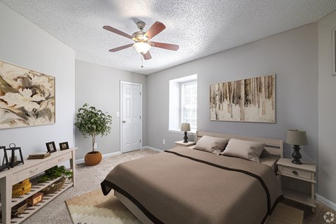 A bedroom with a bed, nightstand, and a ceiling fan.